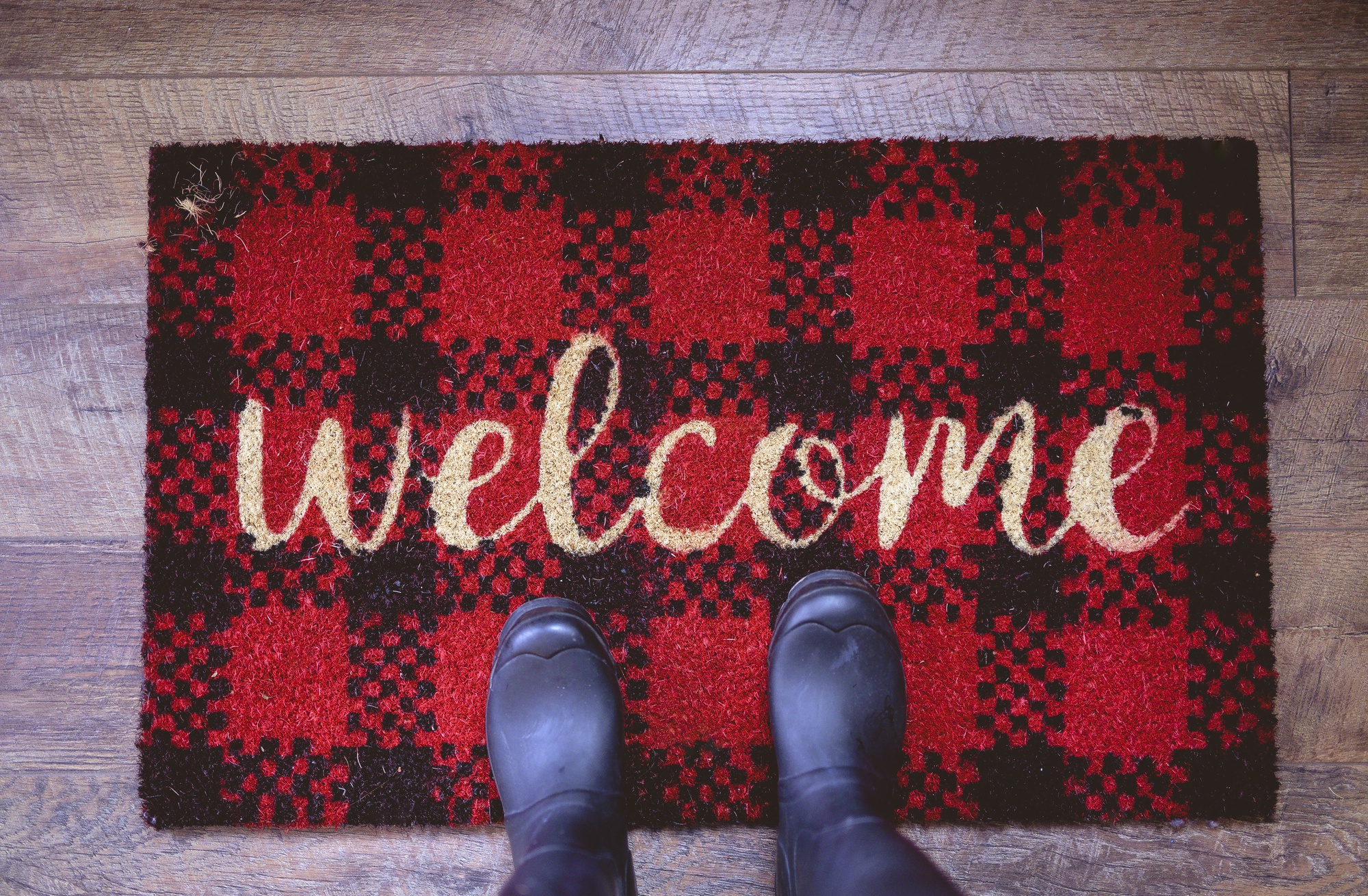 overhead-shot-person-standing-welcome-mat_181624-15888